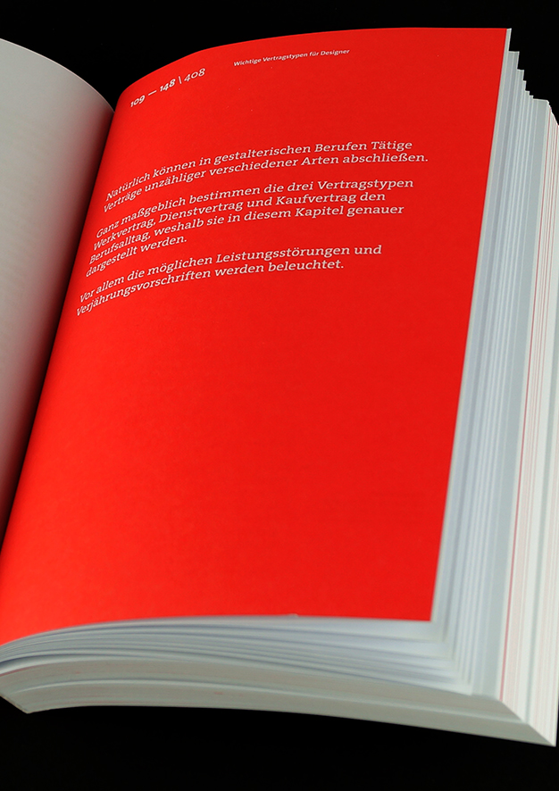 Aufgeschlagenes Buch mit weißem Einleitungstext auf einfarbiger roter Trennerseite. 